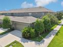 Rear view of townhome showing garage and landscaping at 6357 Shore Vista Pl, Apollo Beach, FL 33572