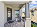 Inviting front porch with a comfortable chair and stylish flooring at 9210 Ballaster Pointe Loop, Parrish, FL 34219