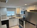 Renovated kitchen with white cabinets, granite counters, and stainless steel appliances at 811 Russell Ln # 309, Brandon, FL 33510