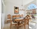 Bright dining room with hardwood table, chandelier, buffet, and large window at 1130 Big Creek Dr, Wesley Chapel, FL 33544