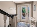 Bright entryway featuring tiled floors, coat hooks, and a front door showcasing the lush outdoor scenery at 210 Lakeview Dr, Anna Maria, FL 34216