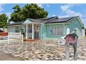 Light teal home with solar panels and stone driveway at 8816 Ascot Ct, Tampa, FL 33634