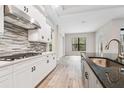 Modern kitchen with white cabinets, granite countertops, and stainless steel appliances at 19411 Sheltered Hill Dr, Brooksville, FL 34601