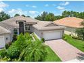 One-story house with a brick driveway and landscaped front yard at 16216 Amethyst Key Dr, Wimauma, FL 33598