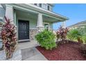 Front entry with teal siding, stone accents and landscaping at 16632 Goose Ribbon Pl, Wimauma, FL 33598