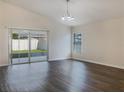 Bright living room with dark hardwood floors and sliding glass doors at 16707 Magnolia Reserve Pl, Wimauma, FL 33598