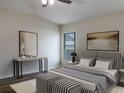 Main bedroom with striped bedding and a ceiling fan at 16707 Magnolia Reserve Pl, Wimauma, FL 33598