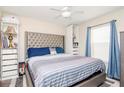 Bedroom with a tufted headboard and blue bedding at 11038 Ancient Futures Dr, Tampa, FL 33647