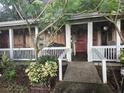 Home features a front porch with white railing and red door at 15222 Lost Lake Ln, Lithia, FL 33547