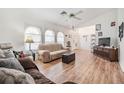 Bright living room features hardwood floors, a comfy sofa, and a large TV at 13199 Drysdale St, Spring Hill, FL 34609