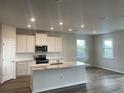 Modern kitchen with white cabinets, granite countertops, and an island at 10622 Eustis Dr, Parrish, FL 34219