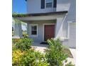 Front entrance with a brown door and landscaping at 14443 Touch Gold Ln, Sun City Center, FL 33573
