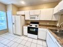 White kitchen with granite countertops, microwave, and electric range at 8628 Hunters Key Cir, Tampa, FL 33647