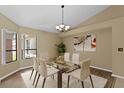 Bright dining room with glass table, chandelier, and hardwood floors at 9506 Pebble Glen Ave, Tampa, FL 33647