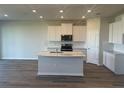 Bright kitchen with a large island, stainless steel appliances, and white cabinets, ready for cooking at 16029 7Th E Ave, Bradenton, FL 34212