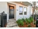 Townhouse entry with black door, gray pavers, and landscaping at 6605 N Nebraska Ave # 27, Tampa, FL 33604