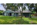 Attractive single-Gathering home with mature trees, freshly painted exterior, and a welcoming covered porch at 8013 N Ola Ave, Tampa, FL 33604