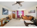 Living room with orange couch, recliner, and ceiling fan at 1240 Chelsea Ln, Holiday, FL 34691