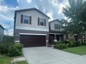 Two-story house with brown garage door and landscaping at 3015 Winglewood Cir, Lutz, FL 33558