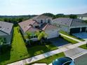 Two-story house with light brown exterior and a two-car garage at 32676 Tree Of Life Ave, Wesley Chapel, FL 33543