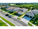 Aerial view of a residential street with houses and landscaping at 32676 Tree Of Life Ave, Wesley Chapel, FL 33543