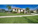 Landscaped front yard with lush grass and palm trees at 887 Clear Lake Dr, Englewood, FL 34223