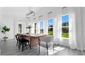 Bright dining room features a rustic wooden table and lake view at 20605 Preston Ln, Lutz, FL 33558