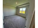 Bright bedroom showcasing neutral walls, plush carpeting, and tray ceiling for a cozy retreat at 18142 Beach Ranch Ter, Lakewood Ranch, FL 34211