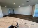 A wide shot of a living room featuring recessed lights and light, wood-look floors at 18142 Beach Ranch Ter, Lakewood Ranch, FL 34211
