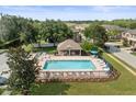 Community pool with a covered patio and lounge chairs at 8491 Essington St, New Port Richey, FL 34654