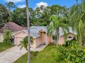 One-story house with a two-car garage and palm trees at 7127 Otter Creek Dr, New Port Richey, FL 34655