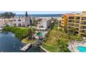 Aerial view of waterfront property with private dock and community pool at 10301 Gulf Blvd # 201, Treasure Island, FL 33706