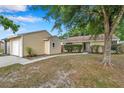 Tan house exterior with one-car garage and walkway at 16203 Lakehead Ct, Tampa, FL 33618