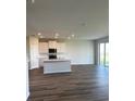 Open-concept kitchen with white cabinets, recessed lighting, an island and sliding glass doors that lead to the patio at 16013 7Th E Ave, Bradenton, FL 34212