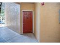 Condo building entryway with red door at 2220 Chianti Pl # 8-0812, Palm Harbor, FL 34683