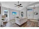 A living room with wood floors, comfortable seating, and ample natural light at 2309 Mooney. Pl, Sun City Center, FL 33573