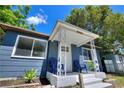 Inviting front porch with cozy seating and fresh landscaping, painted a pleasant blue hue at 3763 Dartmouth N Ave, St Petersburg, FL 33713