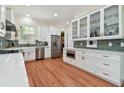 Bright kitchen featuring stainless steel appliances, white cabinets, and hardwood flooring at 6527 Stonington Dr, Tampa, FL 33647