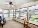 Bright sunroom with a ceiling fan, comfy seating, and views of the surrounding area at 35801 Verda Dr, Zephyrhills, FL 33541