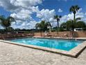 Community swimming pool with lounge chairs and patio furniture at 35801 Verda Dr, Zephyrhills, FL 33541