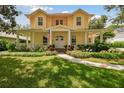 Two-story yellow house with a large porch and landscaped yard at 6527 Stonington Dr, Tampa, FL 33647