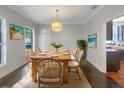 Farmhouse dining room with wood table, wainscoting, chandelier, and beach art at 18122 Sugar Brooke Dr, Tampa, FL 33647