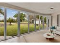 Bright sun room with large windows showcasing a beautiful backyard view at 13102 Prestwick Dr, Riverview, FL 33579
