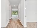 Bright hallway with light wood flooring leading to living areas at 20715 Balsam Hill Rd, Land O Lakes, FL 34638