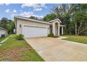 Tan house with a white garage door and driveway at 6439 Taylor Ct, New Port Richey, FL 34653