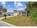 House with a white garage door, mailbox, and a small yard at 6439 Taylor Ct, New Port Richey, FL 34653