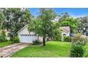 House exterior showcasing a large yard, basketball hoop and landscaping at 5001 80Th Avenue E Cir, Sarasota, FL 34243