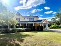 Beautifully landscaped home featuring a covered porch and lush green lawn at 1109 Belcher Rd, Palm Harbor, FL 34683