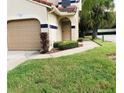 Exterior view of condo with attached garage and landscaped walkway at 10425 La Mirage Ct # 202, Tampa, FL 33615