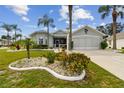 Single story house with landscaped yard and palm trees at 1119 Villeroy Dr, Sun City Center, FL 33573